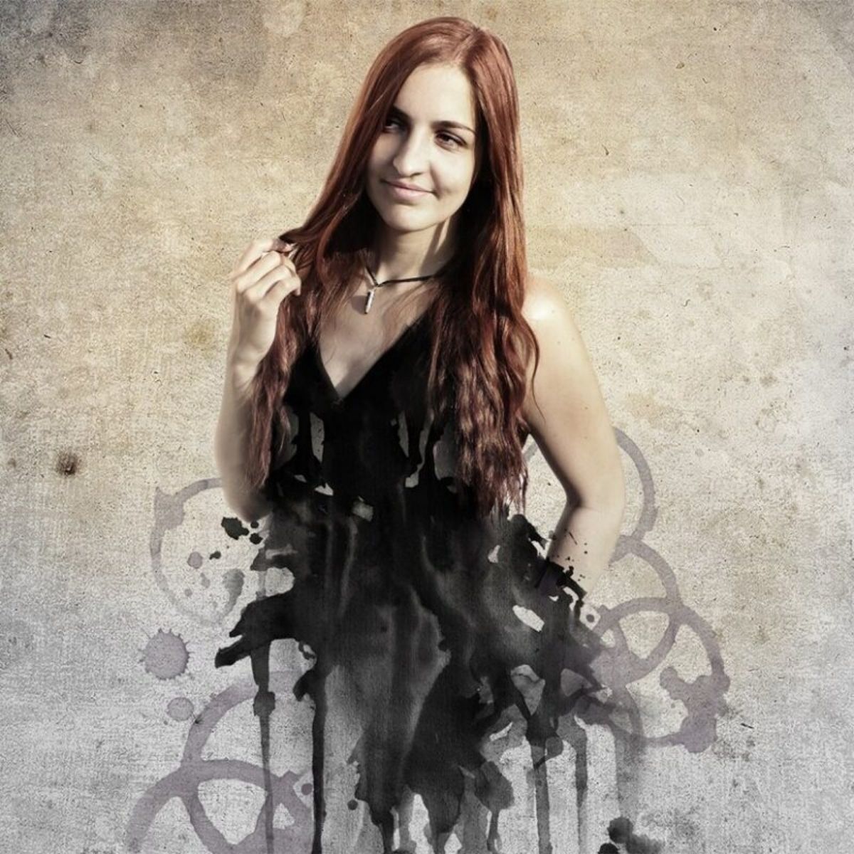 A woman with long red hair wearing a black dress, posed against a textured beige background with dark paint splatter graphics.