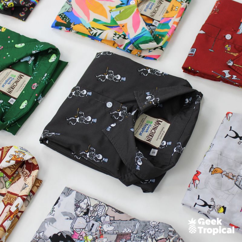 Colorful Geek Tropical Shirts with Munchkin Designs laying down on the floor.