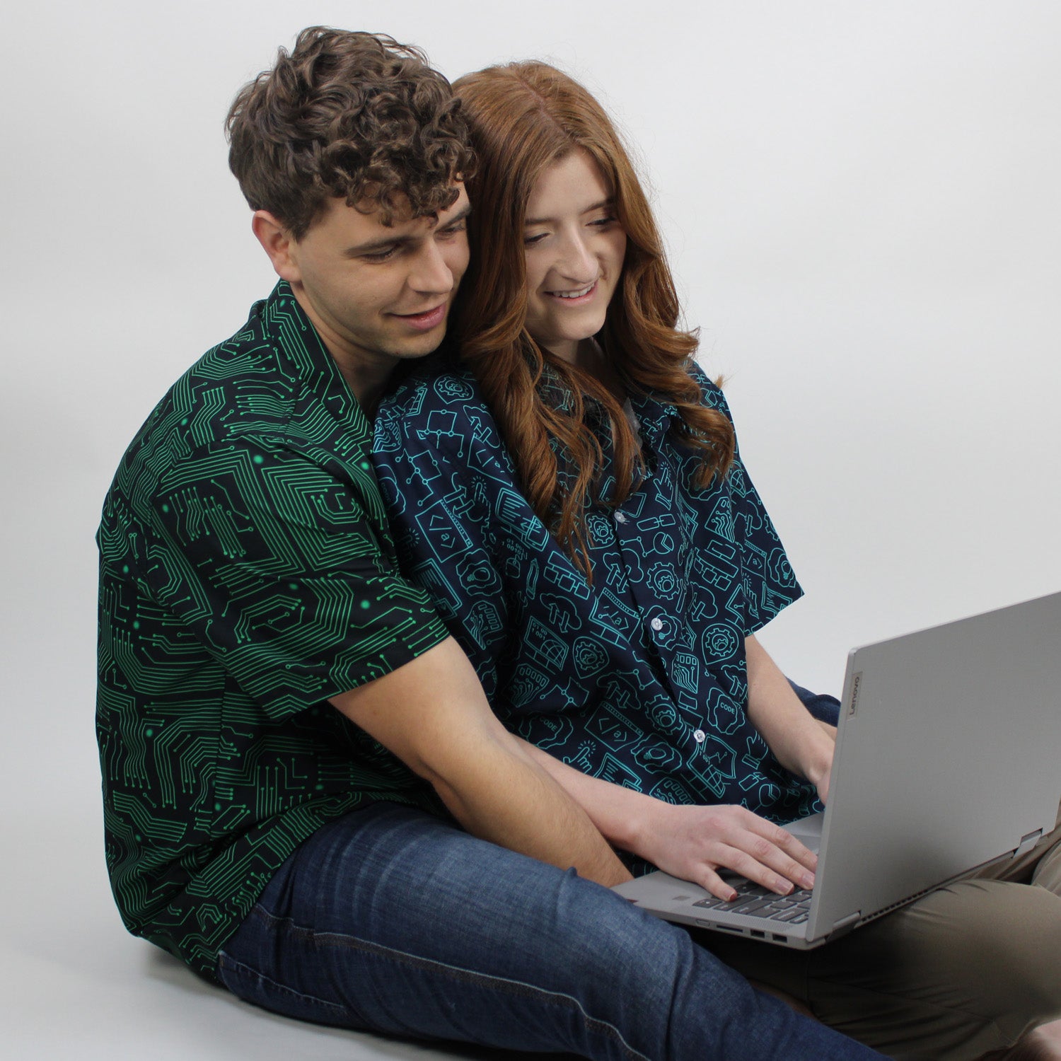 A couple wearing computer circuit board button up shirts.