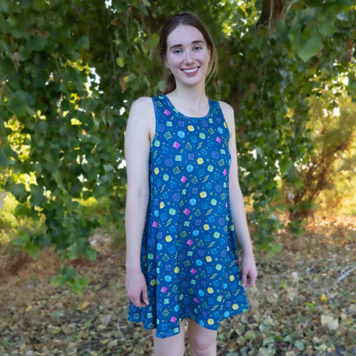 Woman wearing a dnd dice blue dress with standing in a natural setting.